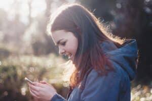 Frau mit Handy in den Händen